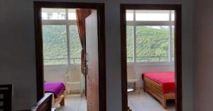 ein Schlafzimmer mit zwei Betten und zwei Fenstern in der Unterkunft Dream View INN in Vālpārai