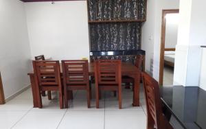 einen hölzernen Esstisch mit Stühlen und einem Spiegel in der Unterkunft Dream View INN in Vālpārai