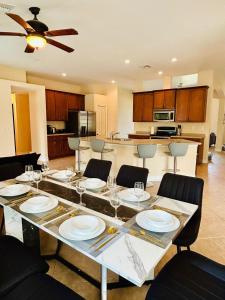 ein Esstisch mit Tellern und Weingläsern in der Unterkunft Waterfront VILLA with heated Pool&Spa, sunset view, Family&Pets Friendly in Cape Coral