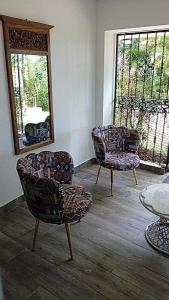 une chambre avec deux chaises, un miroir et une table dans l'établissement Casa Valentina, à Río San Juan