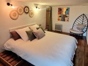 Un dormitorio con una gran cama blanca con almohadas. en Chambre Deborah indépendante, en Le Pradet