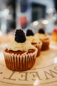 Un cupcake con una mora encima. en Hurtwood Hideout, en Holmbury Saint Mary