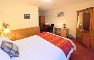 ein Schlafzimmer mit einem Bett und einem Schreibtisch darin in der Unterkunft Hollybank - ensuite room & use of large shared kitchen in Dumfries + 3 Fotos