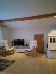a living room with two chairs and a flat screen tv at Mani‘s Appartements in Radstadt