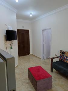 uma sala de estar com um sofá e um banco vermelho em One room apartment em Marsa Alam