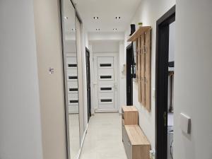 a hallway with a mirror and a wooden bench at Szilvási's Smart Apartman in Eger