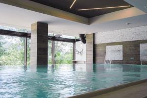 una piscina cubierta con agua en un edificio en Hotel Il Cervo, SPA & Wellness, Bike Hotel, en Tarvisio