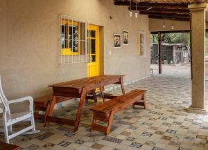 une table en bois et des bancs devant une maison dans l'établissement Cabañas Peumayén Salta, à San Agustín