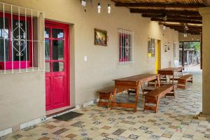 una stanza con tavoli di legno e una porta rossa di Cabañas Peumayén Salta a San Agustín