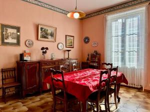 een eetkamer met een rode tafel en stoelen bij Chez Francine et Auguste in Le Puy en Velay
