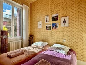 een slaapkamer met een bed voor een raam bij Chez Francine et Auguste in Le Puy en Velay