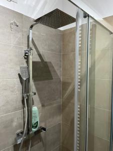 une douche avec une porte vitrée dans une salle de bain dans l'établissement AT HOME Mogliano come a casa ma in vacanza, à Mogliano Veneto