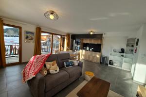 ein Wohnzimmer mit Sofa und Tisch in der Unterkunft Spacieux appartement au pied des pistes in La Feclaz