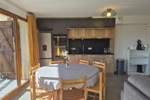 eine Küche und ein Esszimmer mit Tisch und Stühlen in der Unterkunft Spacieux appartement au pied des pistes in La Feclaz