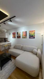 a living room with a white couch and a table at X apartment - Charming 1BR Retreat apartment in Pristina