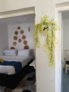 une chambre avec un lit et une plante accrochée au mur dans l'établissement ArChys Homestay, à Gilgil