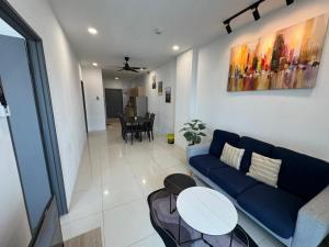 a living room with a blue couch and a table at Princeton Suite @Kuching Airport in Kuching