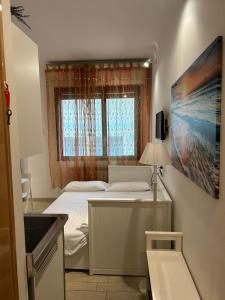 a small bedroom with a bed and a window at Suite Mondial - Rapallo Centro Mare & Wifi in Rapallo +37 photos