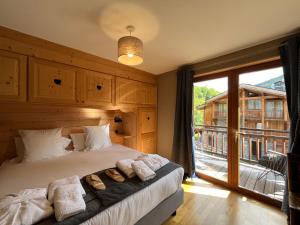 Un dormitorio con una cama con toallas y una ventana. en Le Cochet by Lodji, en Saint-Martin-de-Belleville