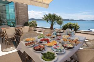 a table with food on it with a view of the ocean at Cunda Kivrak Hotel in Ayvalık