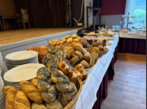 a buffet line with plates and baskets of food at Hotel Sauerland in Alfhausen