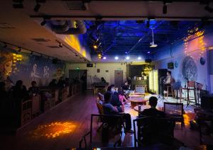 a group of people sitting in a room with a stage at Xi'an YOLO Guest House in Xi'an