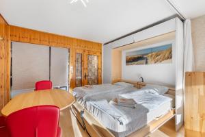 a bedroom with a bed and a table and chairs at Les Bouleaux D1 - 2-4 pers - centre station in Nendaz