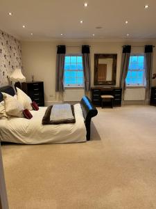 ein großes Schlafzimmer mit einem großen Bett und einem Spiegel in der Unterkunft Meadow Farm in Royal Wootton Bassett