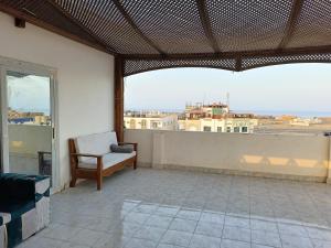 a balcony with a chair and a view of a city at Guest House Science 1 in Marsa Alam City