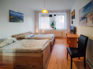 une chambre avec deux lits, un bureau et une chaise dans l'établissement Ferienwohnung Jänschwalde, à Jänschwalde Ost