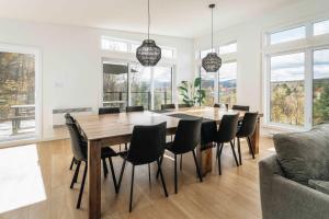 a dining room with a table and chairs at Chalet a Samia - Spa, luxury, Jay Peak view in Mansonville +30 photos