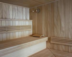 a wooden sauna with two benches and a clock at Fügenschuhs Genussferien in Bad Hindelang