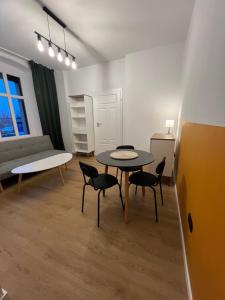 un salon avec une table, des chaises et un canapé dans l'établissement Apartamenty Cytryn, à Gliwice