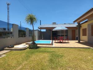 Πισίνα στο ή κοντά στο Casa Com Quatro Dormitórios Pertinho Do Mar Em Capão Da Canoa