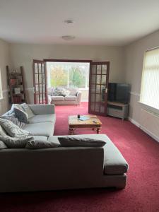 a living room with two couches and a tv at The Holm in Canonbie
