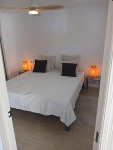 een slaapkamer met een wit bed met twee lampen bij Rincon de Loix Benidorm in Benidorm