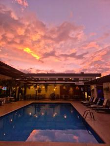 Una gran piscina con una puesta de sol al fondo en KC Hotel San Jose, en San José