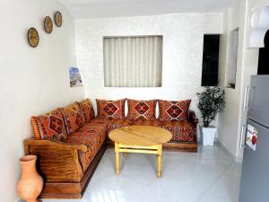 a living room with a couch and a table at Casa Wavy in Taghazout +1 photo