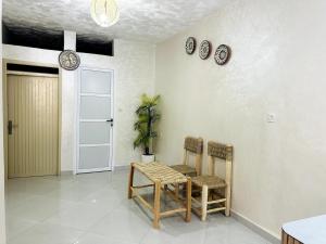 a room with a table and chairs and plates on the wall at Casa Wavy in Taghazout