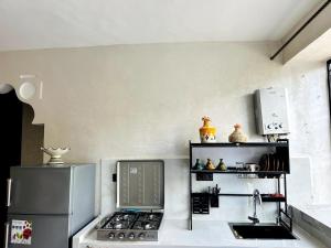a kitchen with a refrigerator and a stove and a sink at Casa Wavy in Taghazout