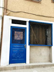 a blue door and two windows on a building at Casa Wavy in Taghazout