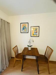 ein Tisch mit zwei Stühlen und ein Tisch mit Blumen darauf in der Unterkunft Hostel City Basel 366 in Basel