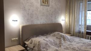 Un dormitorio con una cama y dos luces en la pared. en 2к Апартаменты возле ЖД вокзала и Академии 096-55-48-111, en Khmelʼnytsʼkyy 5 fotos más