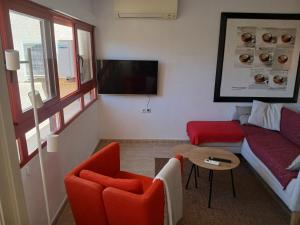 een woonkamer met een rode bank en een tafel bij Rincon de Loix Benidorm in Benidorm