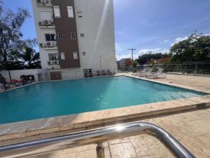 a swimming pool in front of a building at Perfecto para 3 personas. in Boca Chica