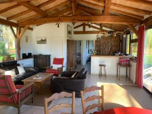 un soggiorno con soffitti in legno e una cucina di Bergerie bucolique a Balizac