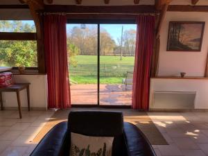 un soggiorno con un divano e una grande finestra di Bergerie bucolique a Balizac 1 altra foto