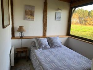 un letto in una stanza con una finestra di Bergerie bucolique a Balizac