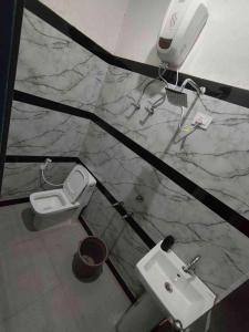 un baño con inodoro y lavabo en Yashdeep Hotel, en Jāmb 18 fotos más