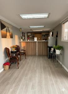 Una sala de estar con mesa y sillas y una cocina. en Quesnel Inn Motel, en Quesnel